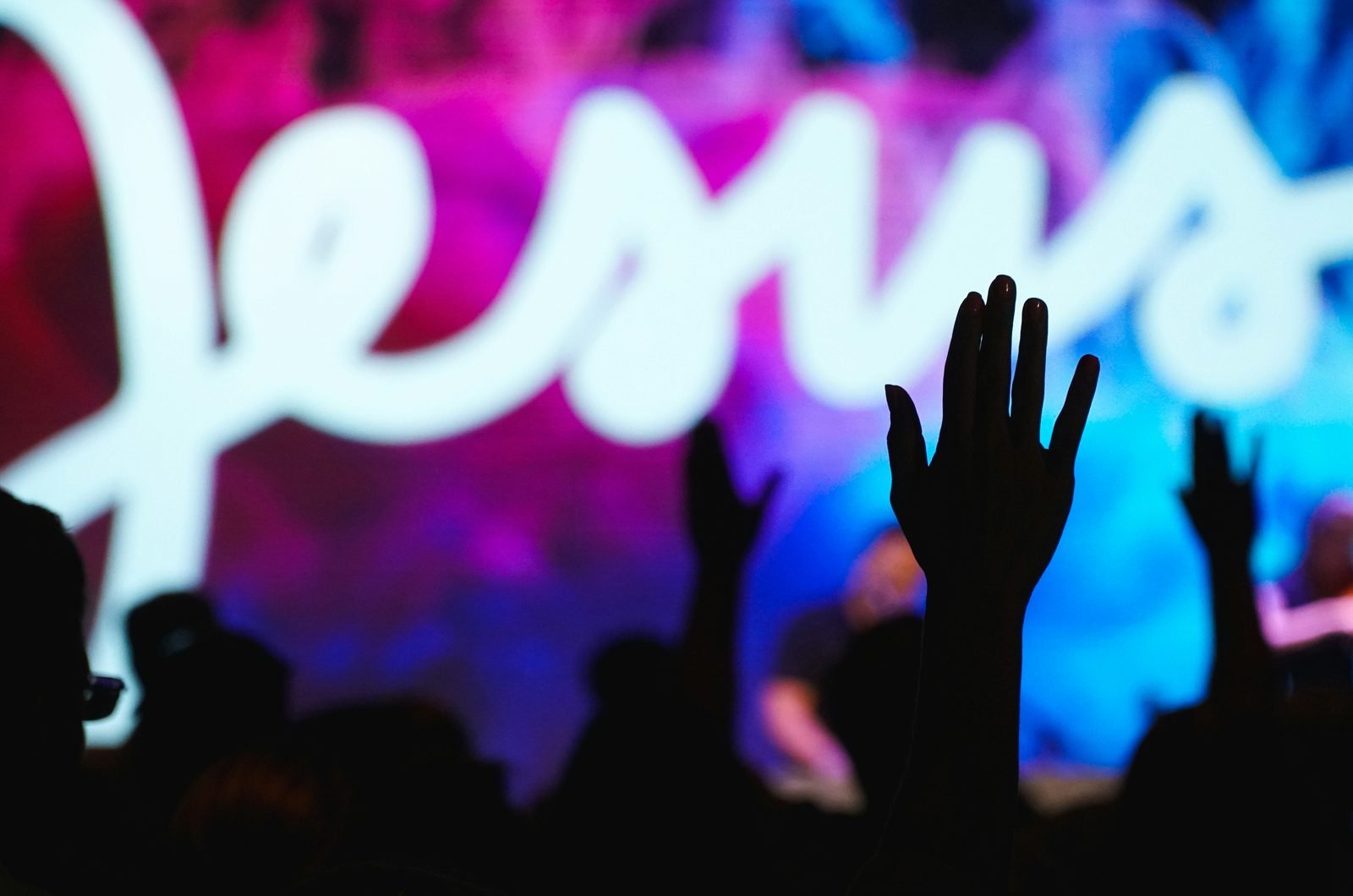Congregation with hands raised in worship at Jesus Harvest Assembly of God